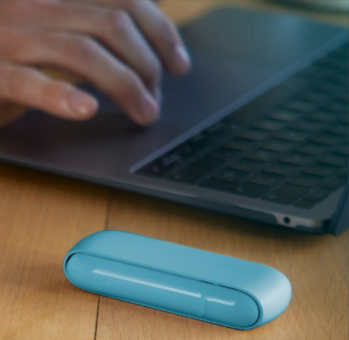 IQOS leżący na stole obok laptopa