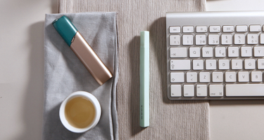 Green and coppery IQOS 3 MULTI kit on a working desk