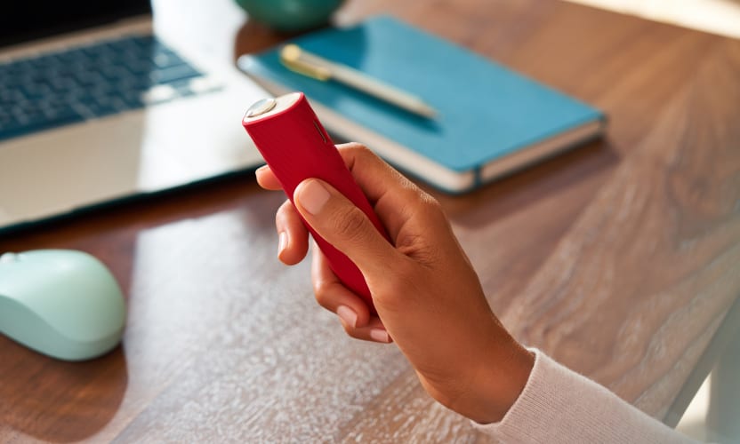IQOS ILUMA ONE w obudowie IQOS trzymany w dłoni