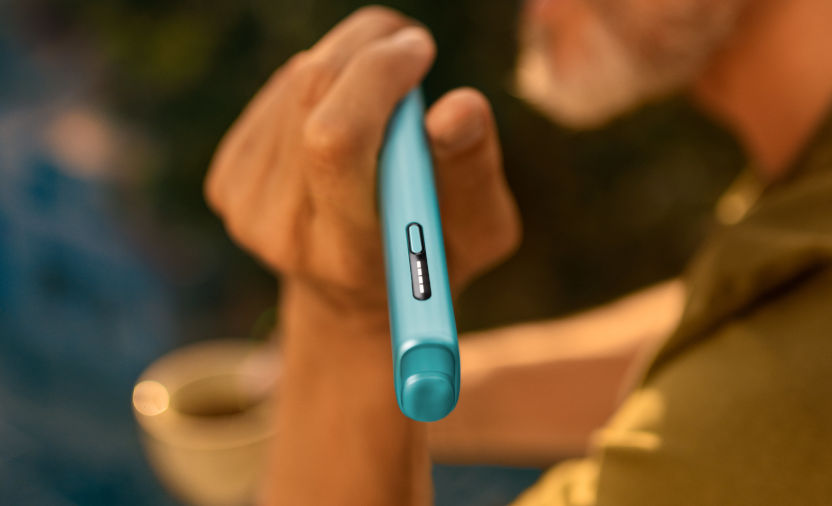 Podgrzewacz tytoniu IQOS ILUMA i ONE w kolorze Breeze Blue trzymany w dłoni