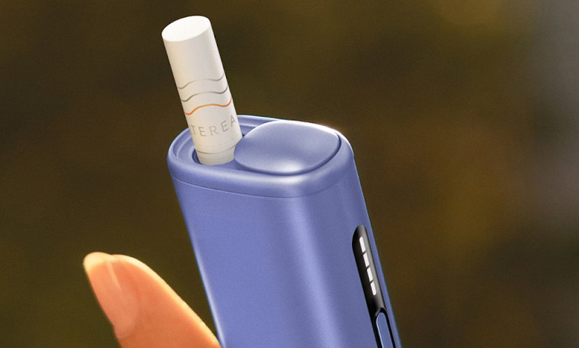 Zbliżenie na podgrzewacz IQOS ILUMA i ONE Digital Violet z wsuniętym wkładem tytoniowym TEREA