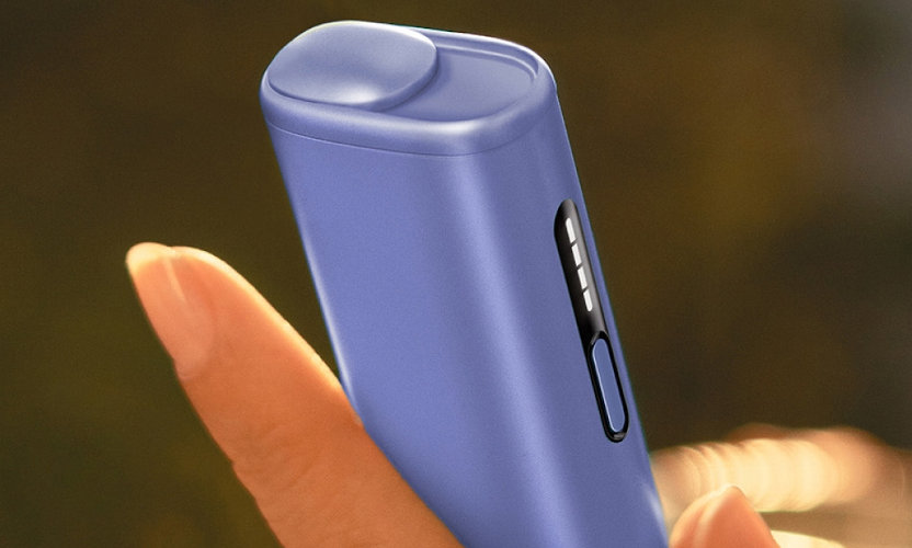 Podgrzewacz tytoniu IQOS ILUMA i ONE w kolorze Digital Violet trzymany w dłoni