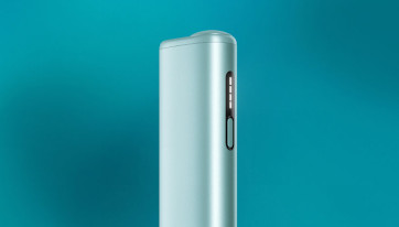 Fragment podgrzewacza IQOS LUMA i ONE na turkusowym tle