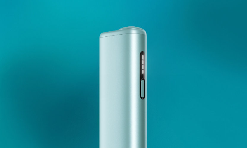 Podgrzewacz tytoniu IQOS ILUMA i ONE w kolorze Breeze Blue, stojący na turukusowym tle